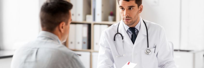 Male patient taking a referral for a Sunshine Coast Radiology scan from his doctor in a white coat with stethoscope