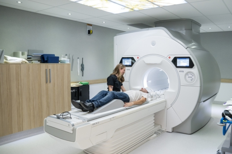 MRI technologist reassures patient before they go into an MRI scanner.