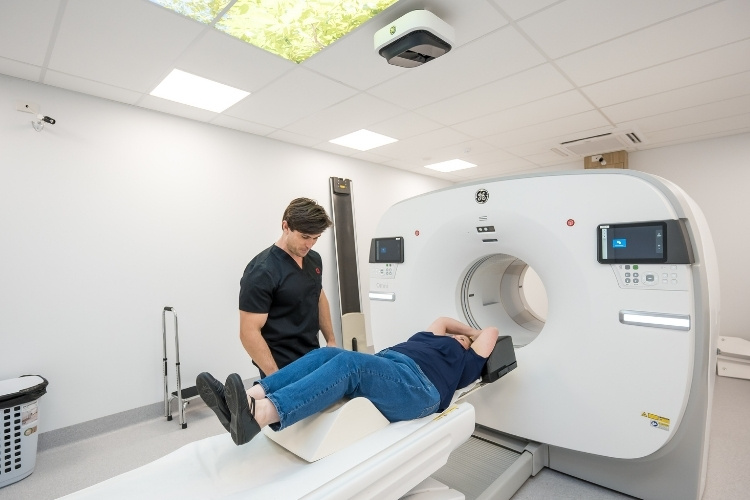 Nuclear Medicine Technologist prepares female patient to enter PET CT scanner.