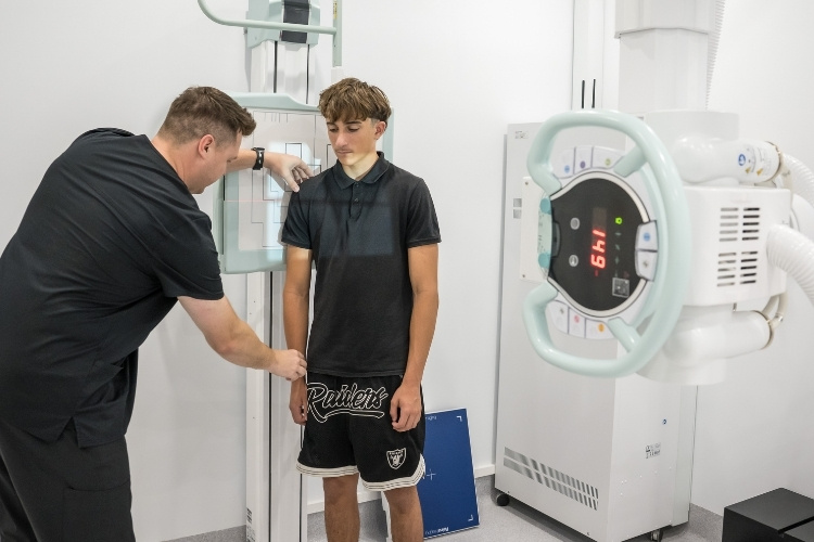 Radiographer positions young male patient for an X-ray at Sunshine Coast Radiology.
