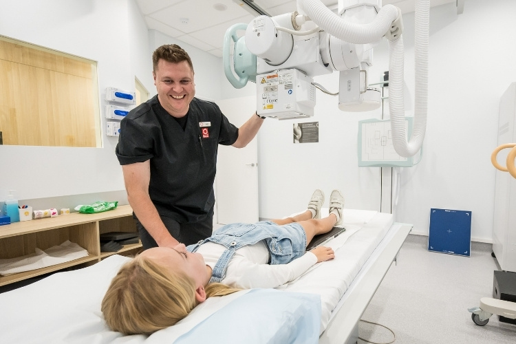 Radiographer speaks with patient as he prepares to take X-ray at Sunshine Coast Radiology.