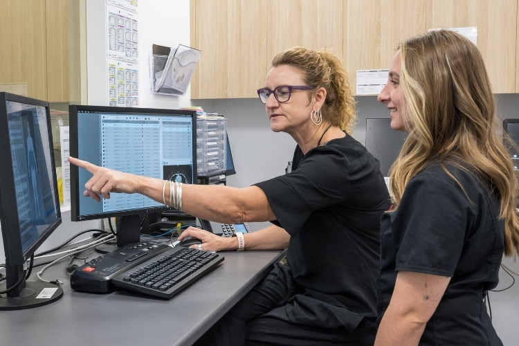 Two radiographers plan an interventional procedure at computer.